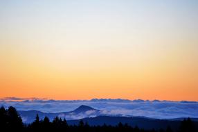 mountain peaks among clouds at dusk