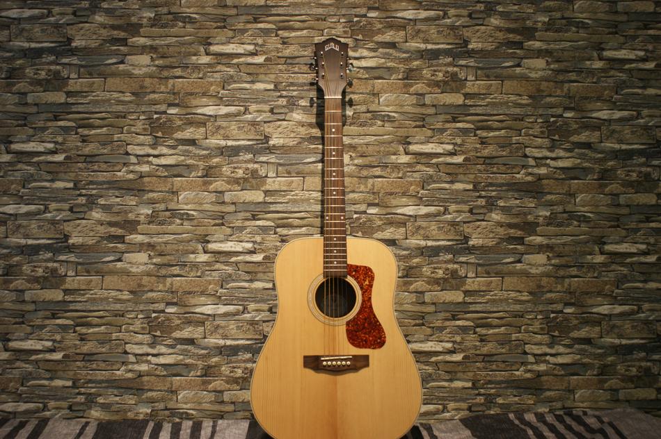 acoustic Guitar at stone wall