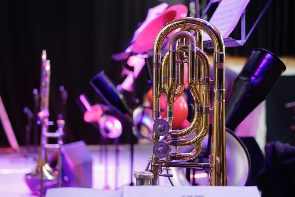 Close-up of the beautiful, shiny trombone, on the stage, on the concert, with the lights, among the darkness