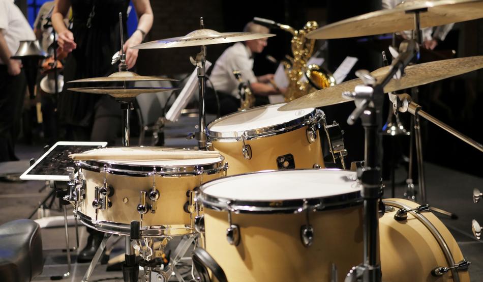 Drums and gold saxophone on the stage with the people