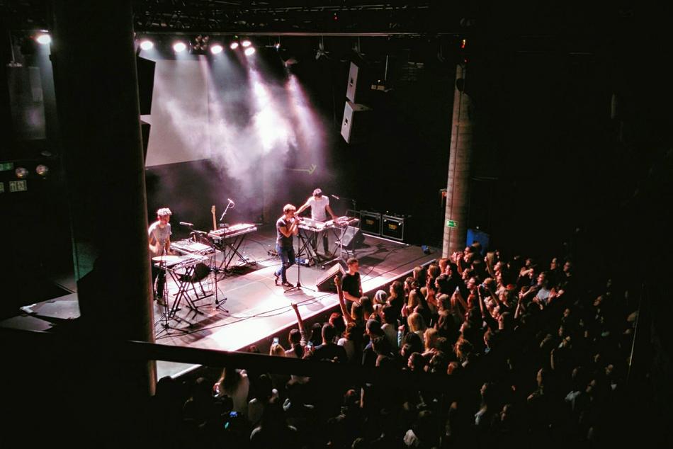 Perfomance of the band on the stage with the crowd near it