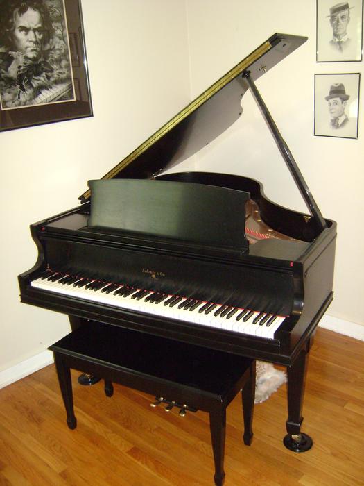 black and wihte piano and bench in the museum