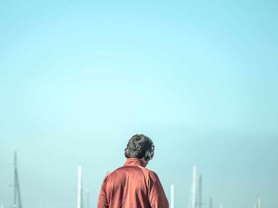 man with headphones over blue sky