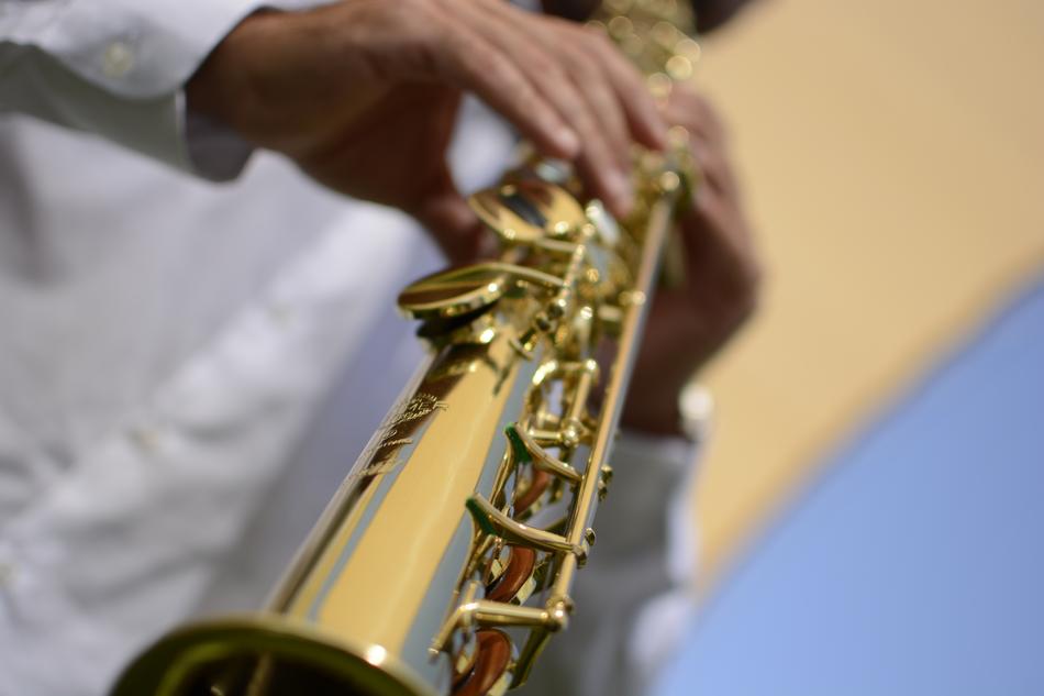 Person in white shirt, playing on the shiny musical instrument
