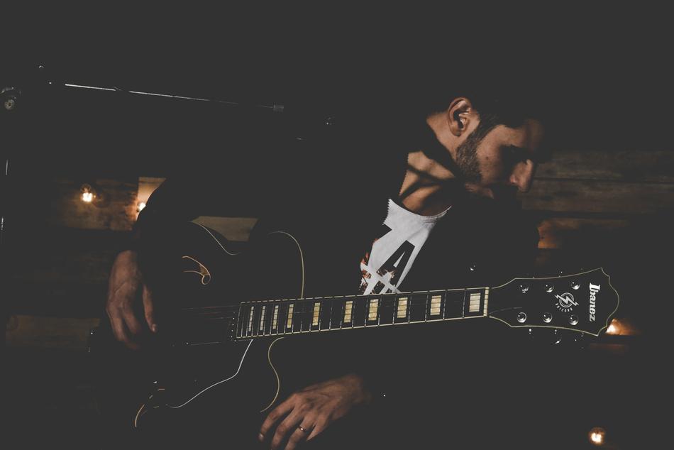 musician with a guitar in light and shadow