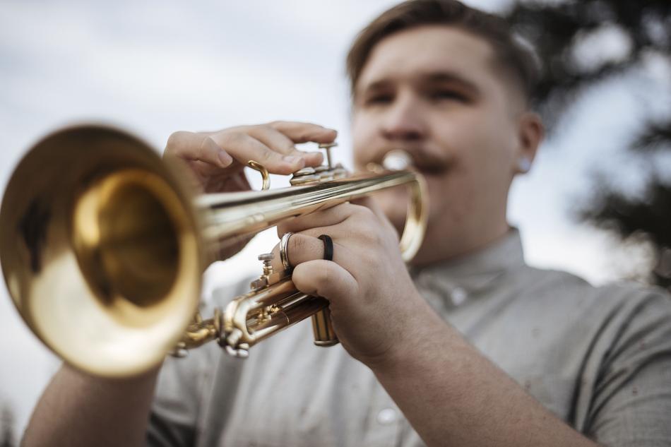 guy with shiny gold trumpet at blurred background