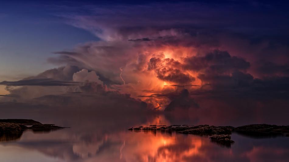 Beautiful and colorful sunset in the clouds above the ocean with thunderstorm