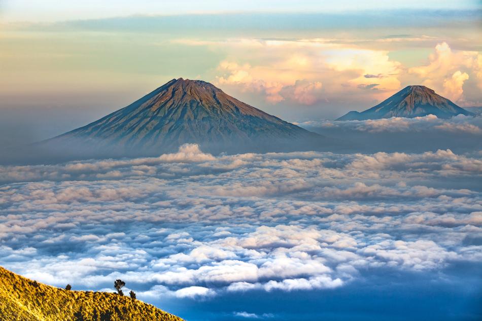 Beautiful landscape of the colorful Sumbing and Sindoro mountains among the beautiful sea of clouds in Central Java, Indonesia