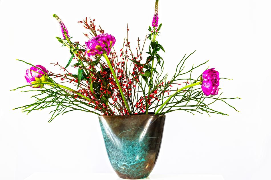 Close-up of the colorful and beautiful Ranunculus bouquet in the colorful vase, at white background