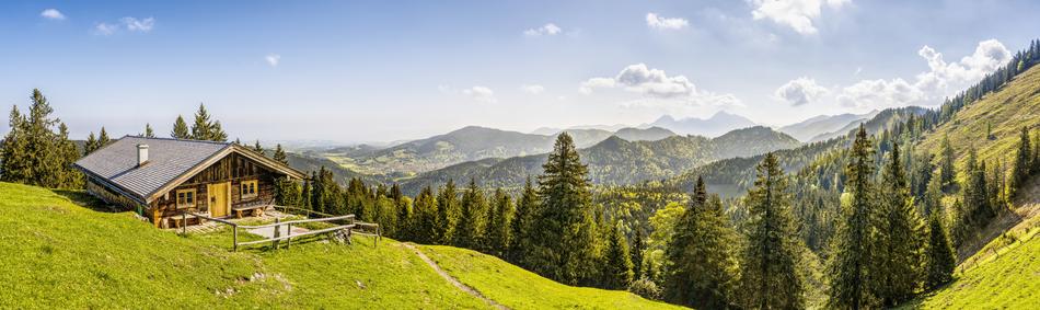 Beautiful landscape of the green Alpine mountains with trees and wooden hut in Upper Bavaria, Bavaria, Germany