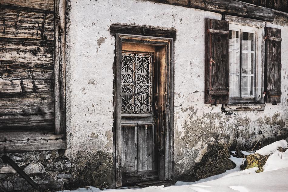 Beautiful, old, white house with the decorated door, among the snow, in winter