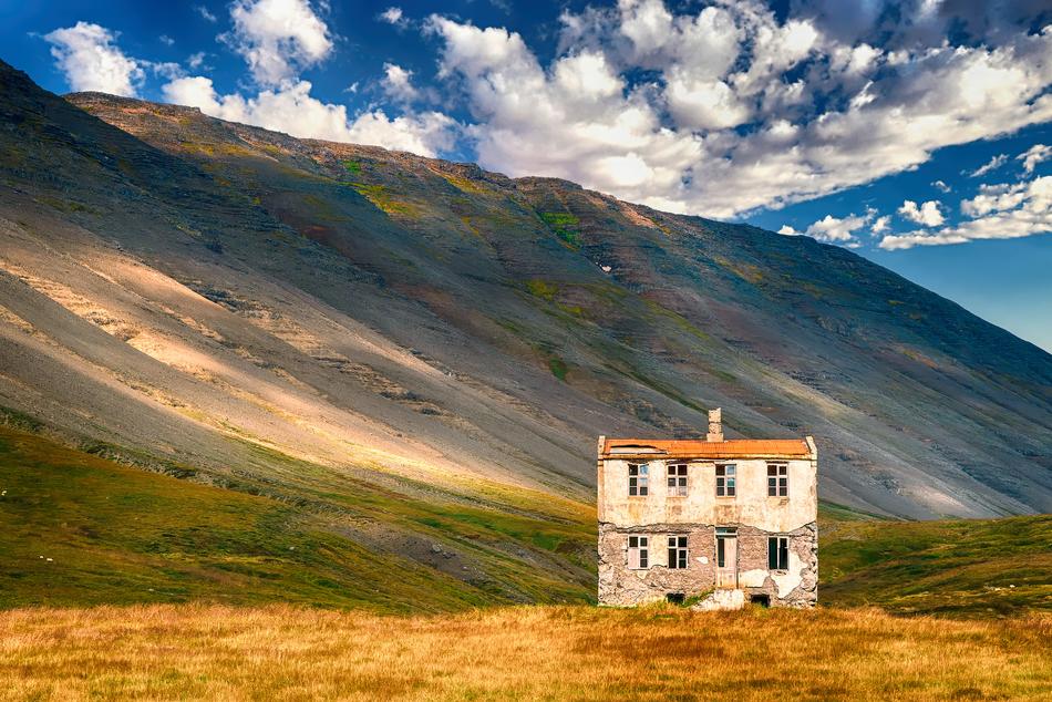 Abandoned Building on meadow near mountain at autumn