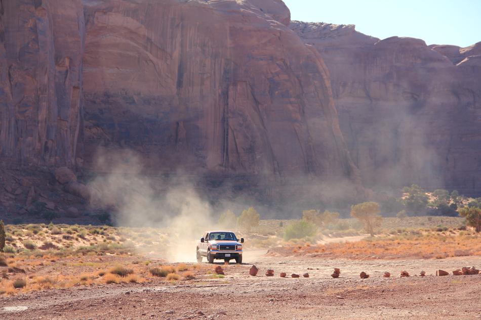 car on a dusty road in monument valley in arizona