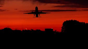 Silhouette of the aircraft at red sunset background in America