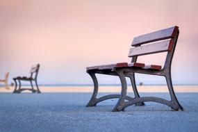 benches on sea sand in pink twilight