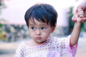 portrait of asian child holding parent's hand