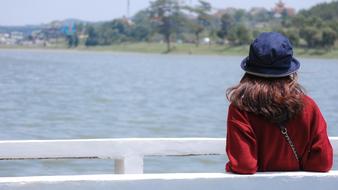 a girl stands with her back on the pier in Vietnam