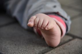 bare foot of kid on the pavement