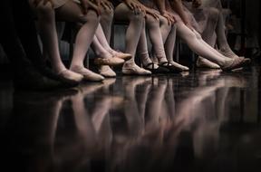 Legs of the ballerina girls, on the floor with reflections