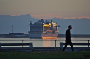 young man on the embankment against the background of a large ferry in Palma de Mallorca, Spain