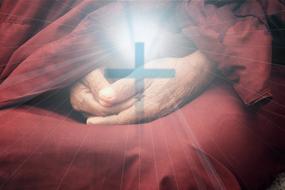 silhouette of the christian cross over hands