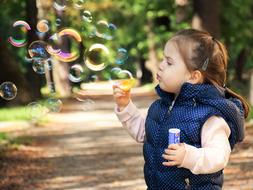 little girl with soap bubbles on the street