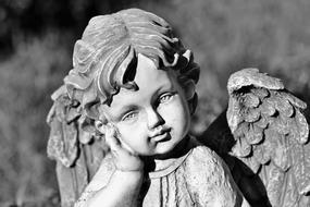 Black and white photo of the cute Angel stone figure in the garden