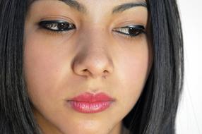 Portrait of the woman with makeup looking down on white background