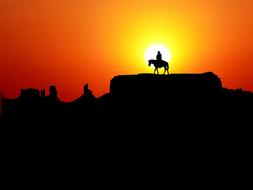 Silhouette of the man on horse at colorful sunset background