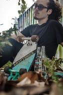 young Boy with skateboard sits on ground