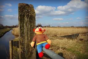 handmade soft Toy on fence in countryside