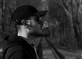 young man blowing smoke outdoor