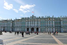 People, on the beautiful square near the Hermitage, with the flag, in St Petersburg, Russia