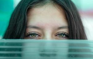 face of young Young Woman behind transparent screen
