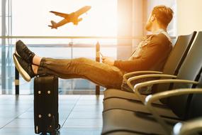 man with suitcase in the airport lounge