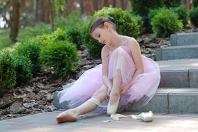 little ballerina on the stone stairs in the park