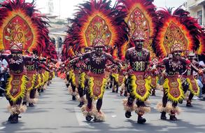 tribal men in carnival costumes parading on Street, Philippines, iloilo