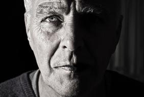 Black and white portrait of a man with half of the face in shadow