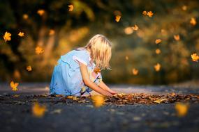 blonde girl under the autumn leaves