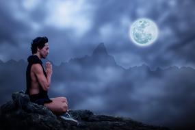 a man meditates on a rock against the background of the moon
