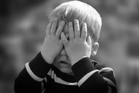 black and white photo of a boy with a closed face