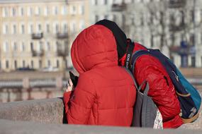 two people wearing winter clothing in city, back view