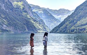two child Girls Wading through water at scenic mountain landscape