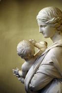 Beautiful, white marble statue of the woman, with the child in France