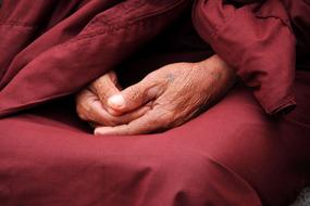 Hands of elderly Buddhist monk