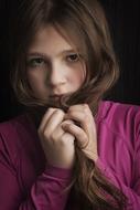 portrait of a girl in a pink sweater with long hair