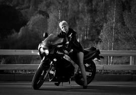 Black and white photo of the girl on the motorcycle on the road