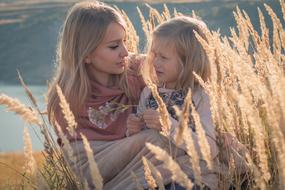 photo of mom with daughter in flowering grass