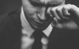 monochrome, man wipes away tears