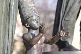 bronze sculpture of a child in a high hat